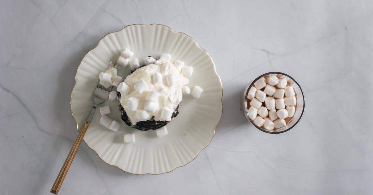 Brown sugar instead of white sugar - Top view of plate and fork with delicate white marshmallow and chocolate topping near cocoa