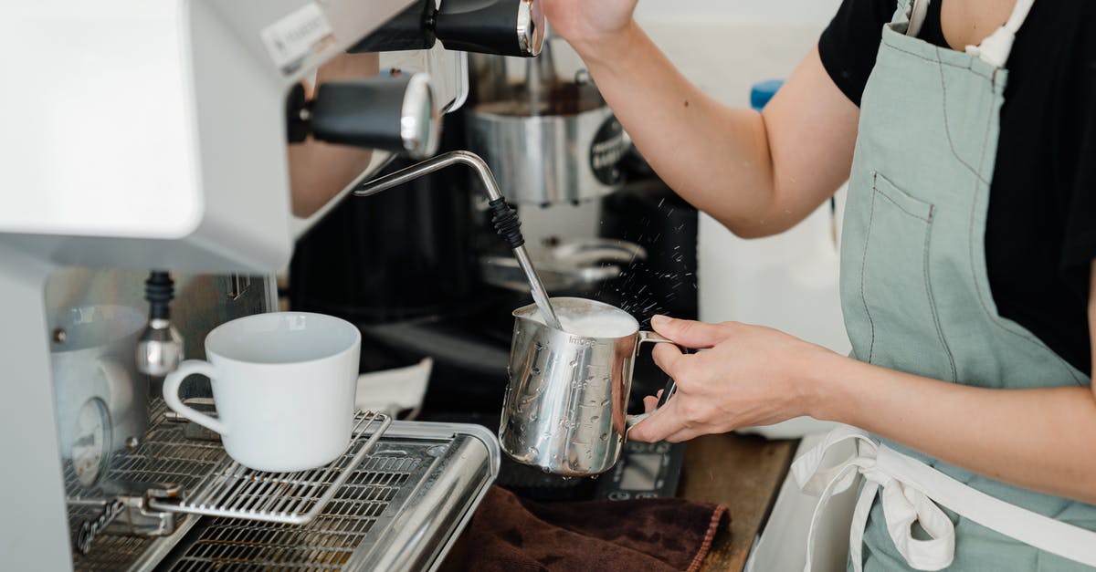 Bunn coffee maker parts cannot be identified - Crop faceless young female barista in apron steaming milk in steel pot using modern cappuccino machine