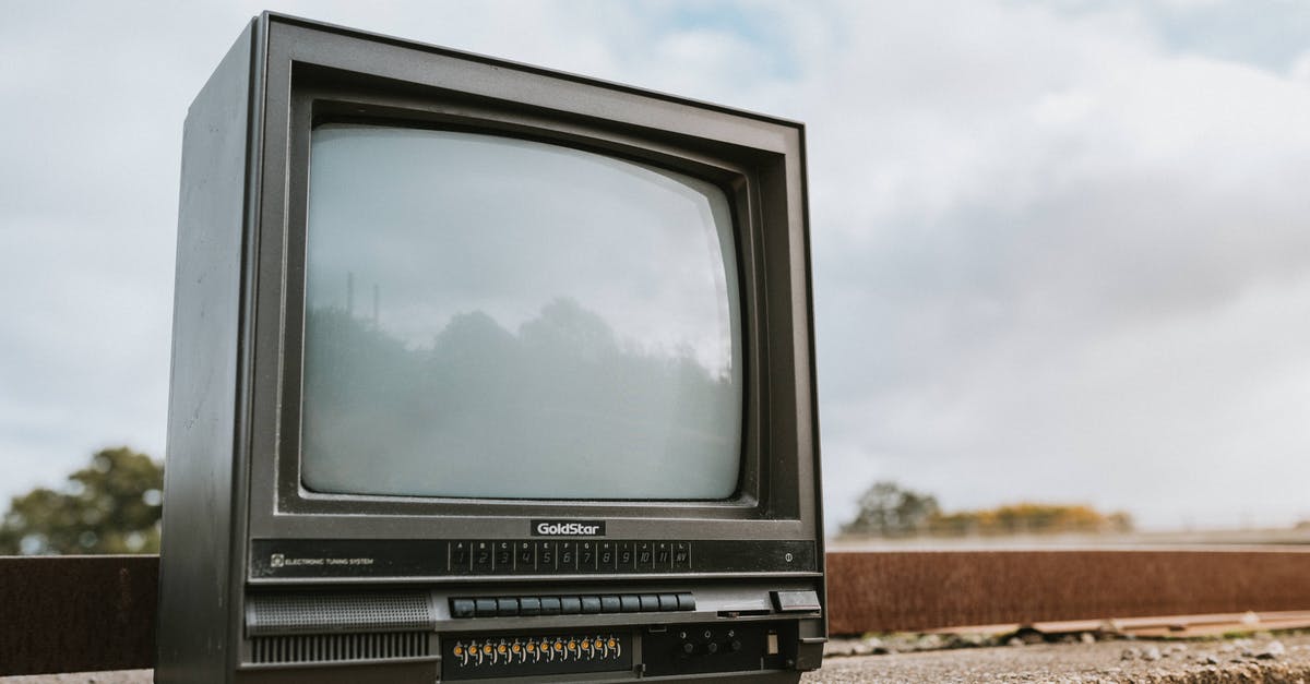 Burned / black pizza stone - Vintage TV set placed on stone barrier