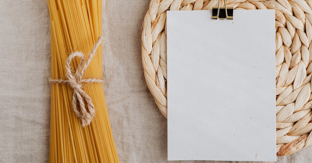 Butcher/Cooking Twine - safe for BBQ? - From above of blank paper placed on wicker table mat next to spaghetti tied with bow arranged on table covered with linen tablecloth suitable for recipe or ingredient listing