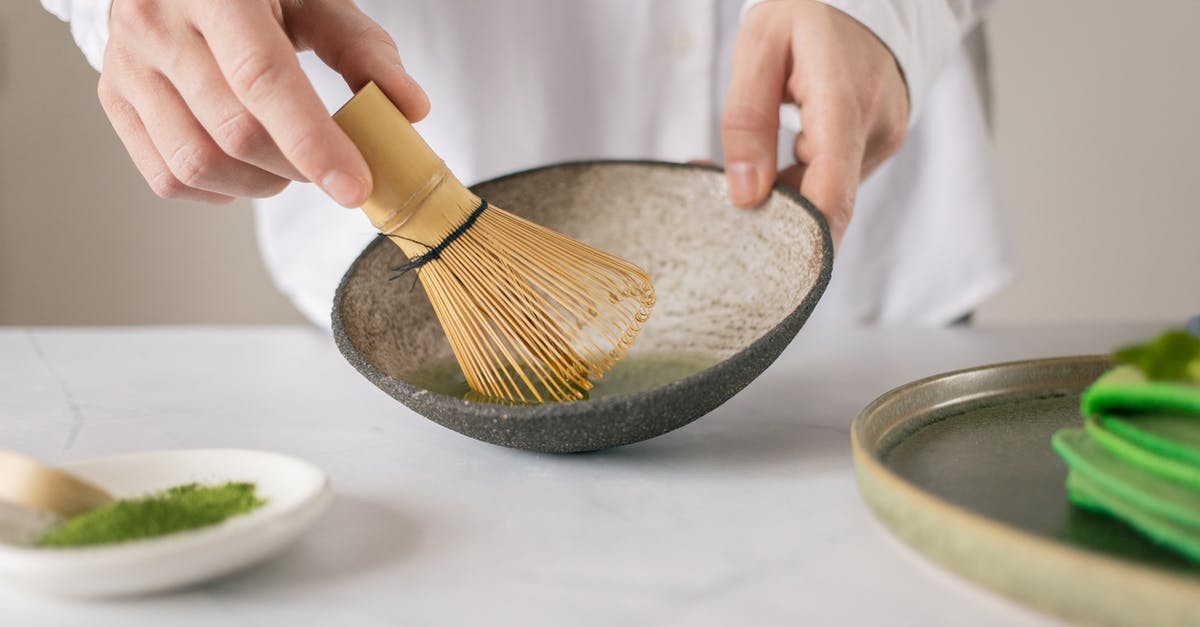 Buttermilk pancake mix is green? - Crop unrecognizable cook in white shirt mixing dry food coloring with water in bowl using whisk on table with green pancakes