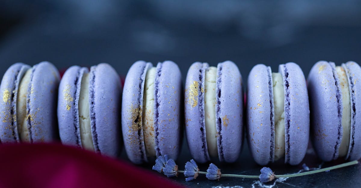 Butterscotch Pie setting - Set of delicious sweet macaroons in violet color with white cream served on table in bakery with flower