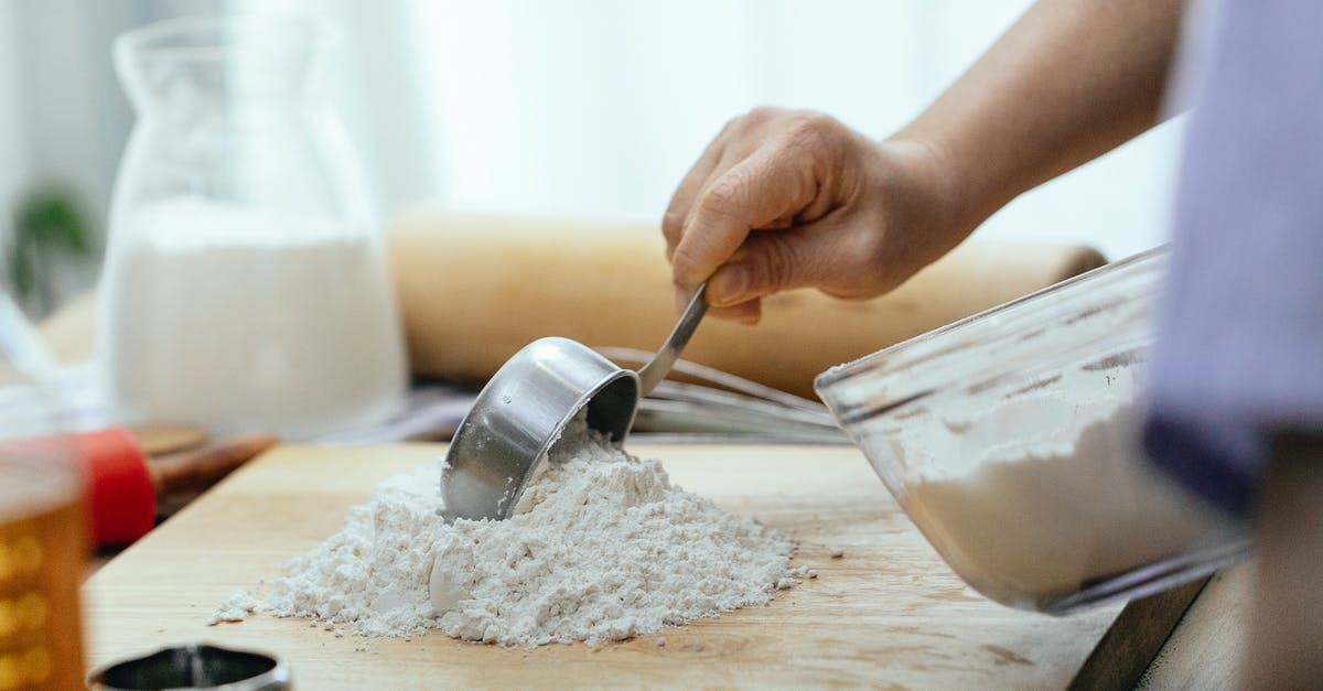 Cake batter consistency - Crop adult woman adding flour on wooden cutting board