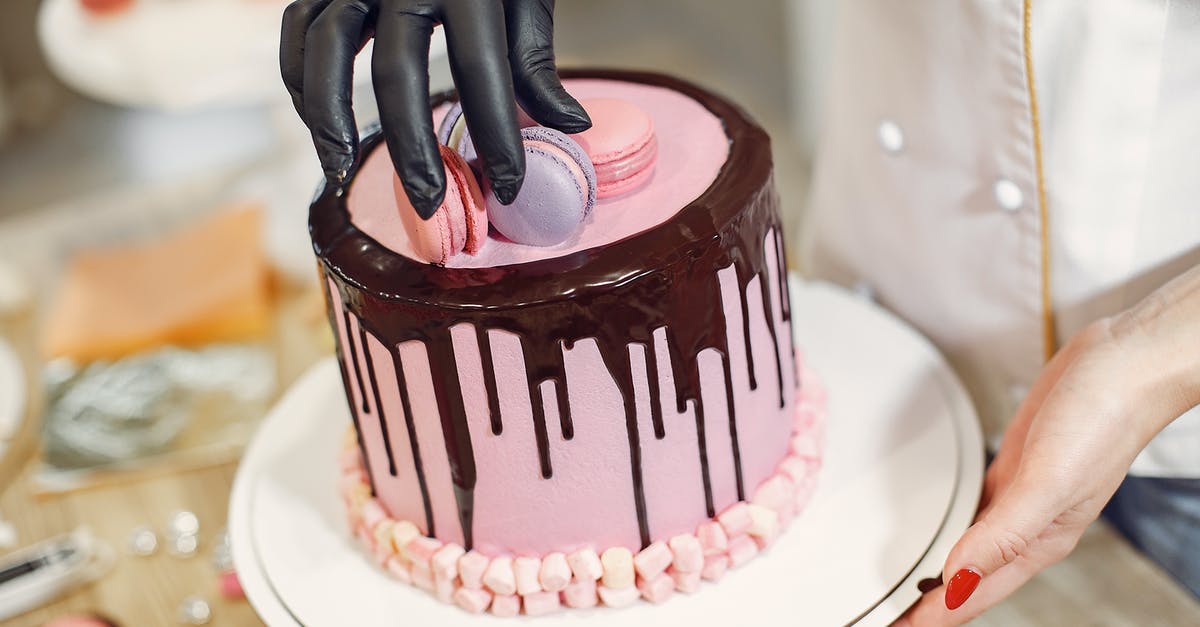 Cake with ganache on top going to the freezer - From above crop anonymous woman arranging macaroons on top of cake with chocolate drips while working in pastry store