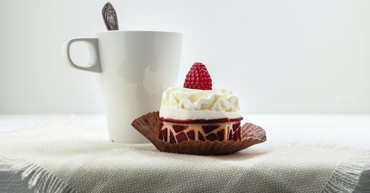 Cake with ganache on top going to the freezer - A Raspberry Cake Near the Ceramic Cup