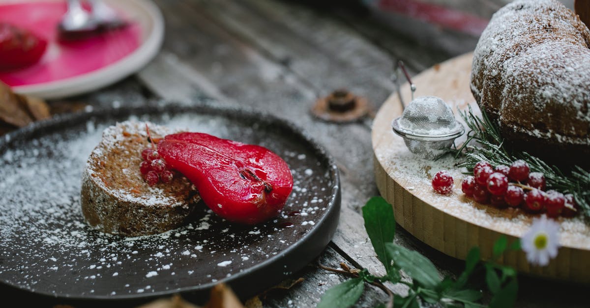 Cake without baking powder made 2 layers in a cake. Why? - Appetizing composition of freshly baked sweet pie served on black plate with red marinated pear and decorated with sugar powder