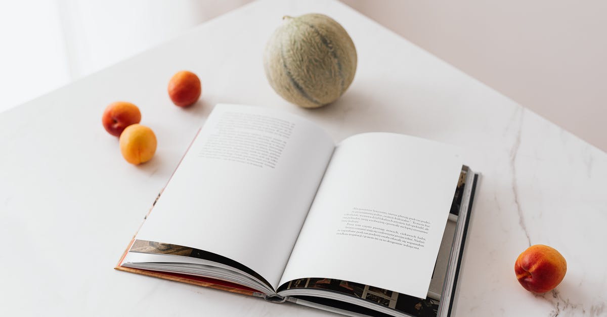 Calculating Nutrition Information for Commercial Food Labeling - Fresh fruits scattered on table near opened textbook