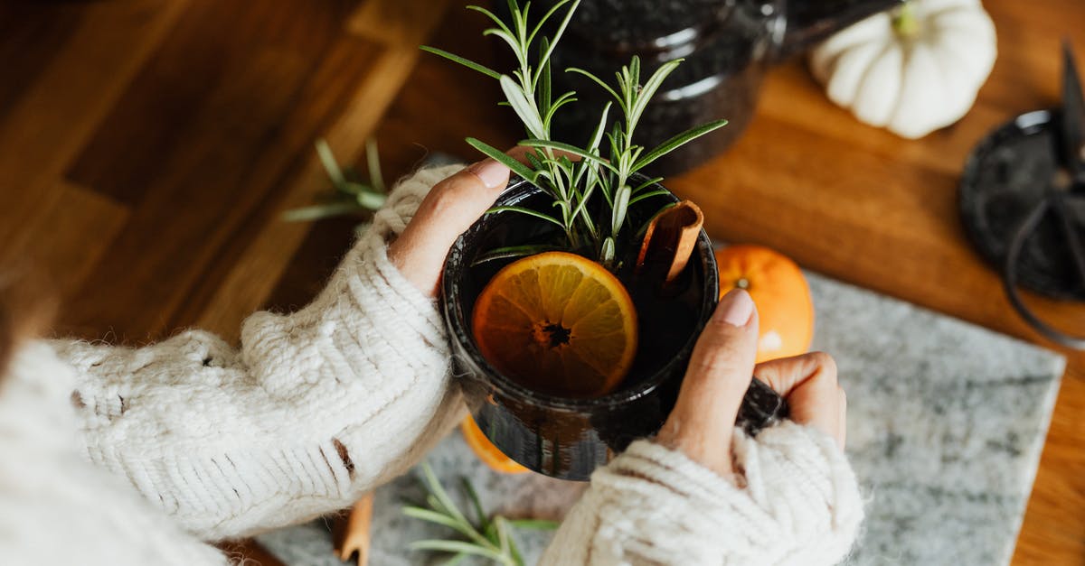 Calibrating tea dosage - Woman Holding a Cup of Tea with a Lemon Slice and Herbs 