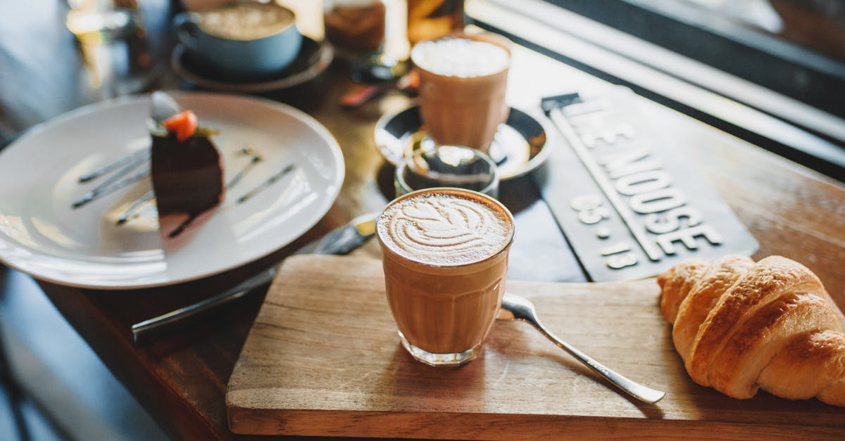 Calories in a lava crunch cake - From above of glass of cold coffee drink served with fresh crunchy croissant on wooden board near plate with chocolate cake in cozy cafe