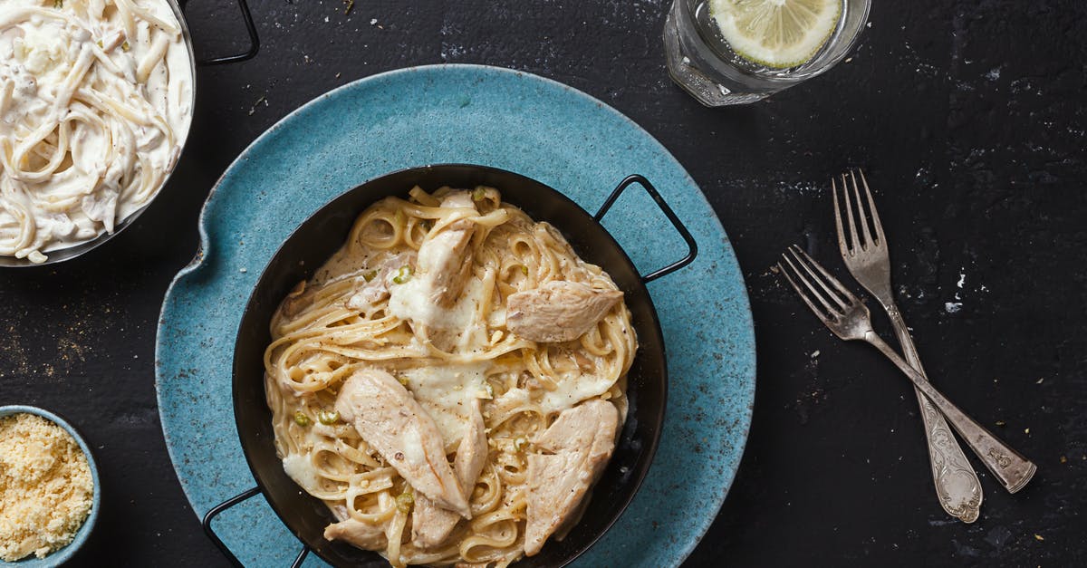 Calories in (cooked) pasta - Pasta Dish on Black Ceramic Bowl Near Forks and Glass With Water