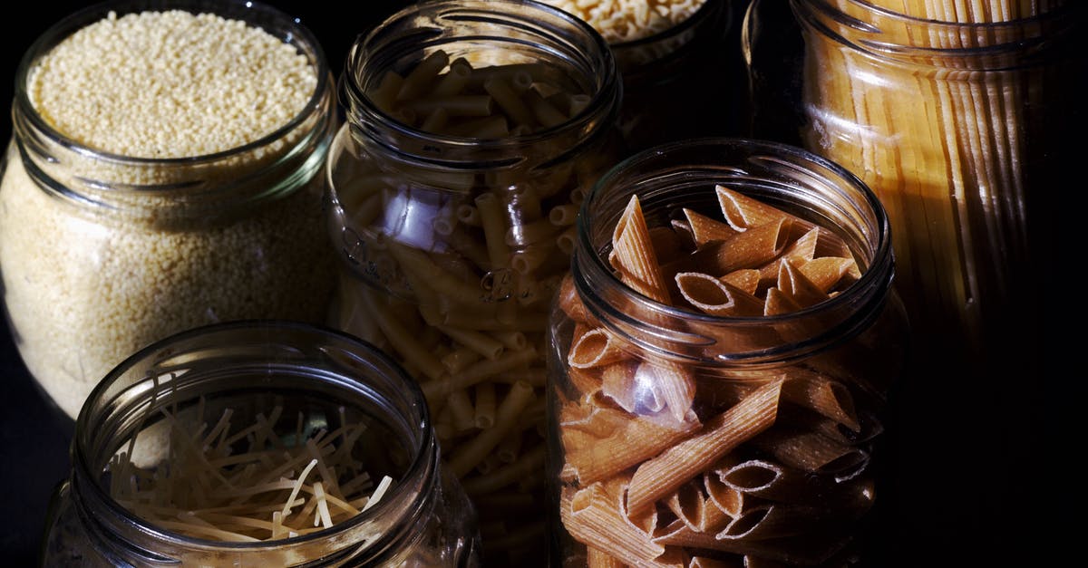 Calories in (cooked) pasta - Different types of pastas and cereals in glass jars on kitchen in sunlight