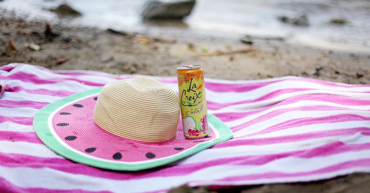 Can a fish living in fresh water be called seafood? - Striped towel spread on sandy beach with straw hat and juice can