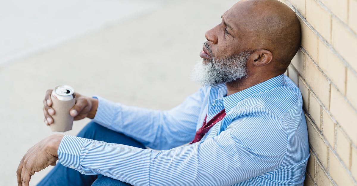 Can alcohol evaporation get you drunk? - Depressed black male with beer can leaning on brick wall