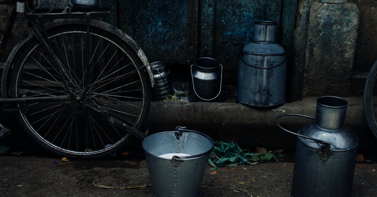Can almond milk be used as a sauce base? - Tin vessels and metal bucket with milk placed near bike leaned on shabby rusty wall