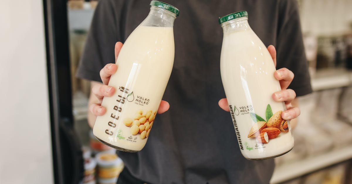 Can almond milk be used as a sauce base? - Person Holding Bottles with Milk