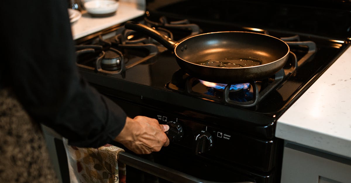 Can an enameled dutch oven be used for stir frying? - Crop faceless woman adjusting rotary switch of stove