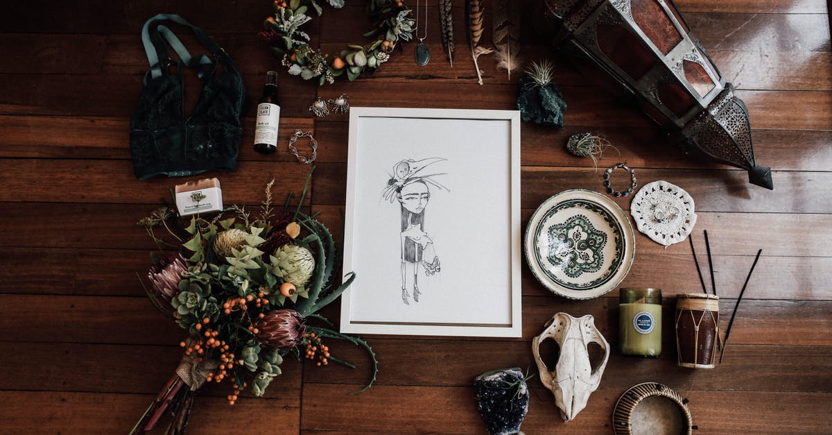 Can an old rosette “iron” that's starting to stick be reconditioned? - Top view of frame with illustration among flower bouquet and lantern near amulets on wooden surface