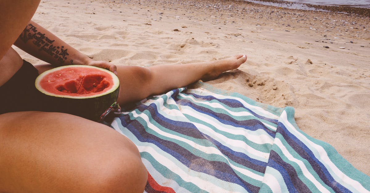 Can any harm come of eating watermelon seeds? - Person Eating Watermelon by the Beach