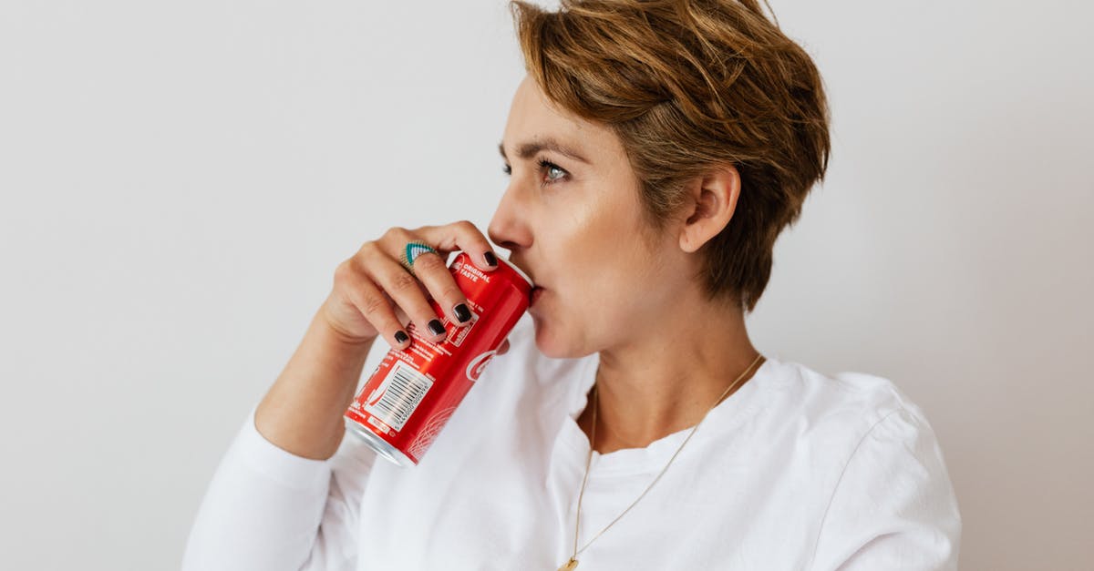 Can anyone identify this RED GINSENG CANDY? - Pensive female in white wear with gold necklace and ring on finger drinking cold coke from red can and looking away