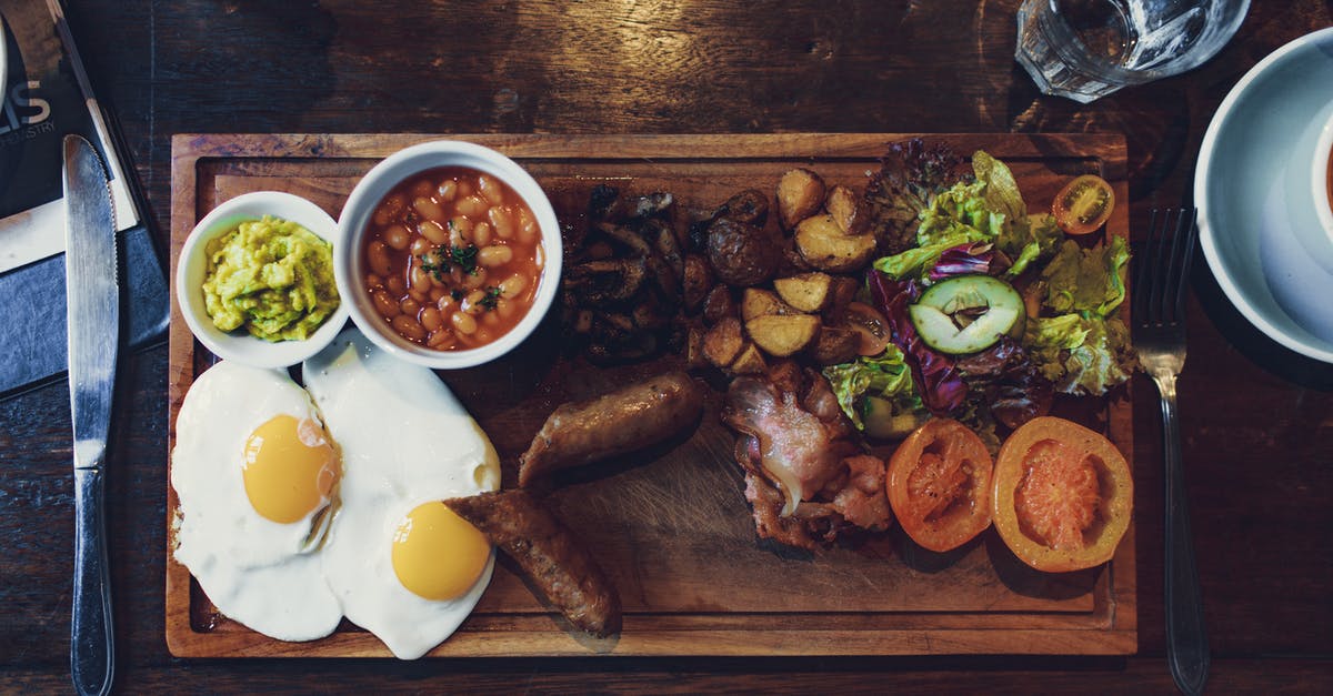 Can bad potato salad be made into something good? - Top view of delicious fried eggs and vegetables with sausages and beans on wooden tray with fork and knife