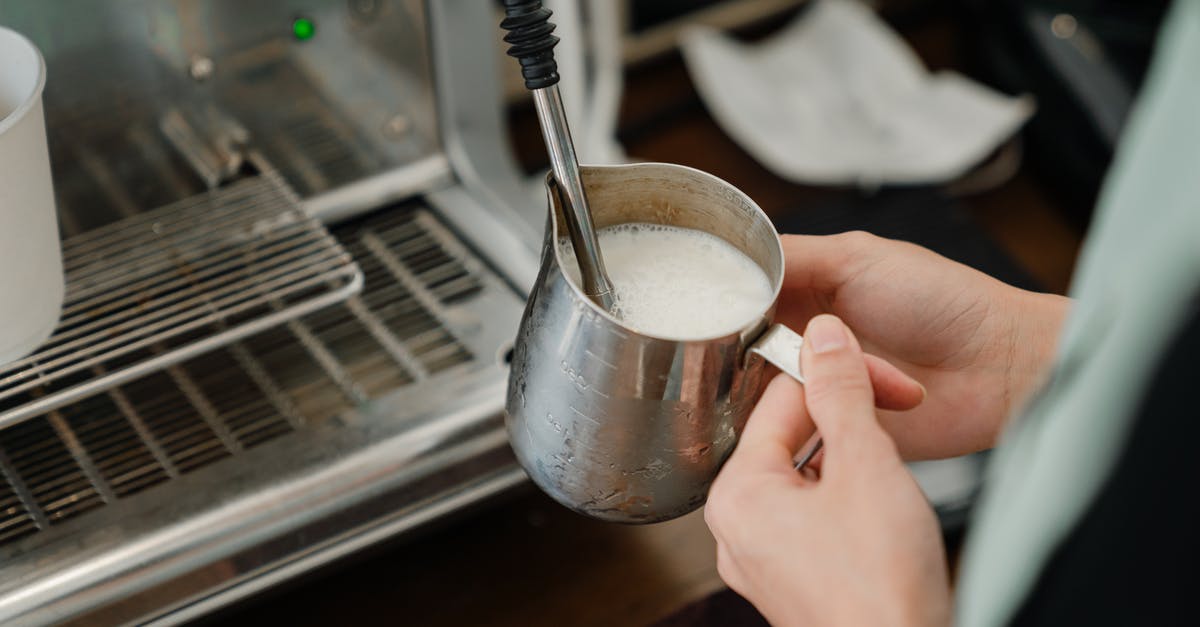 Can bean-to-cup machine make quality espresso/cappuccino? - Crop barista whipping milk in stainless steel cup