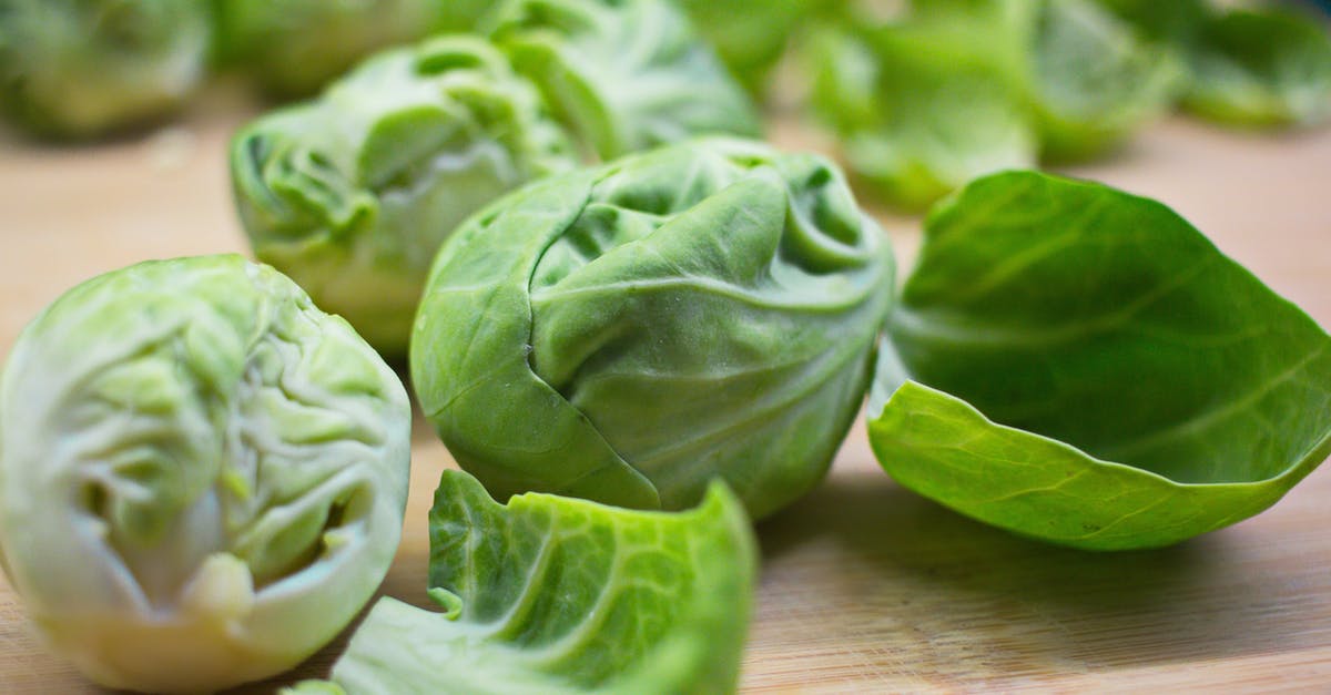 Can Brussels sprouts be eaten raw? - Closeup of ripe fresh Brussels sprouts with peels placed on wooden cutting board