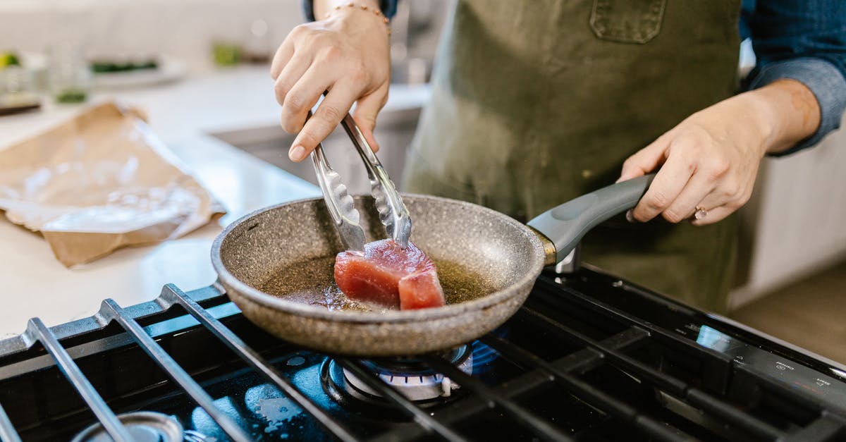 Can deep frying oil be too hot? - Female Hands Holding Frying Pan and Putting Chunk of Meat in Hot Frying Oil