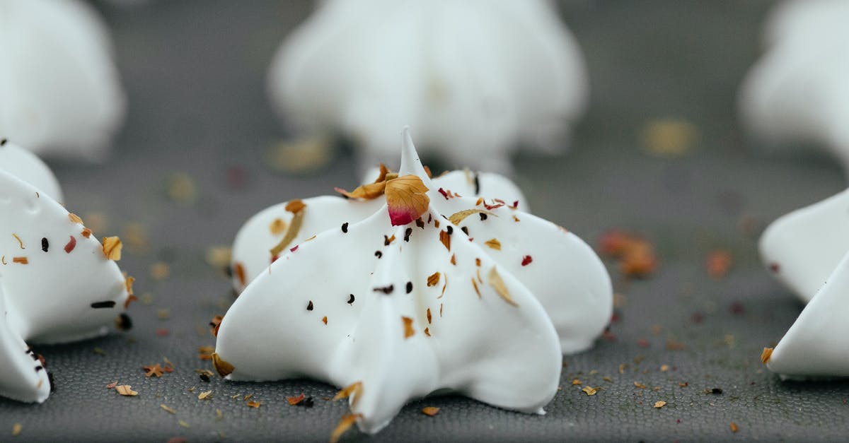 Can frozen egg whites be used in a macaron recipe? - Closeup of uncooked white meringue dessert with mix of dry spices on top on baking pan