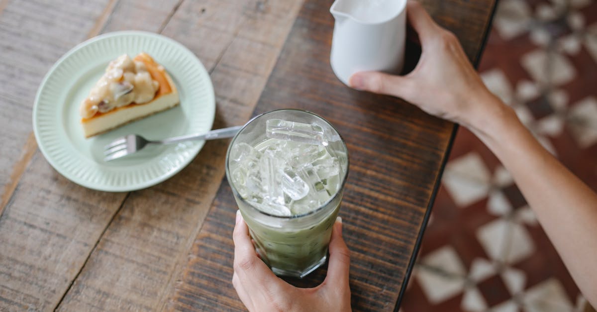 Can I add double cream to my cake batter instead of sour cream? - From above crop anonymous female preparing delicious iced matcha latte while sitting at table with sweet pie
