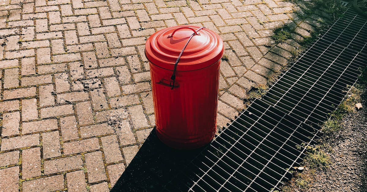 Can I adjust soup texture right before serving? - High angle of red metal trash can placed on pavement near sewer grates in city street in sunny summer day