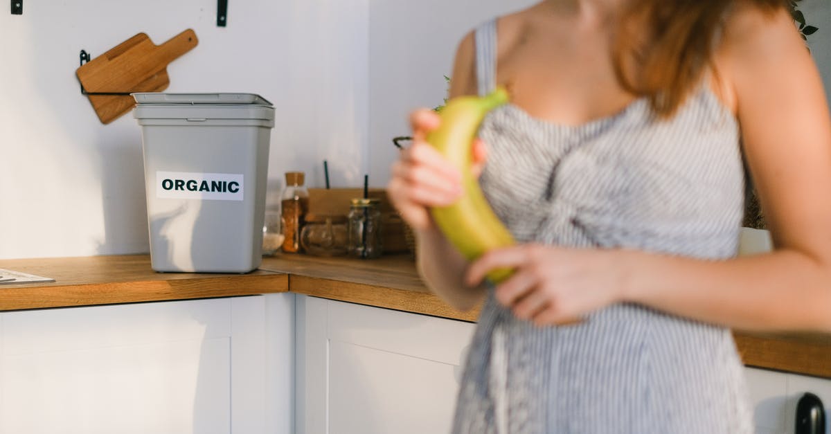 Can I freeze fruit shrub? - Crop woman with organic banana in hands standing in kitchen