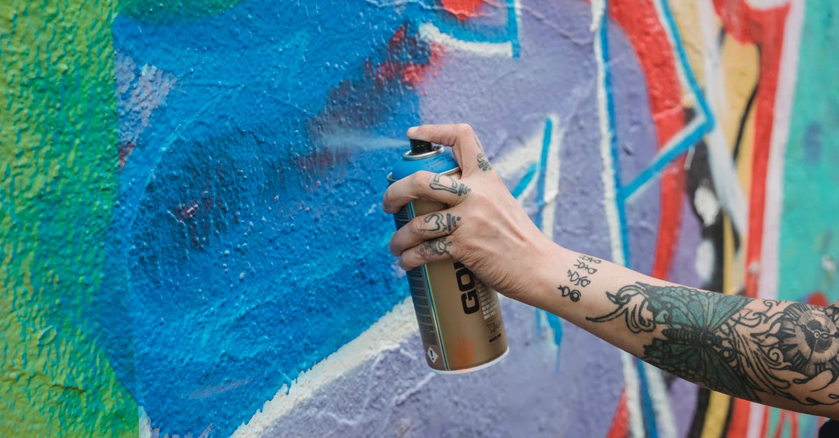 Can I freeze ricotta hand pies? - Crop unrecognizable tattooed painter spraying blue paint from can on multicolored wall with creative graffiti while standing on street in city