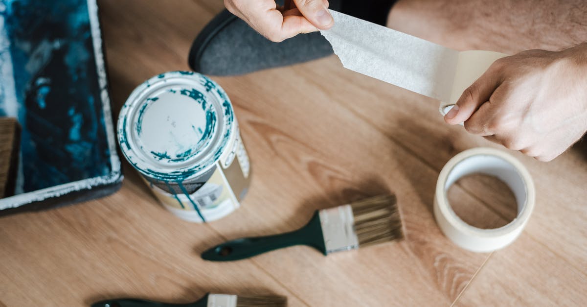 Can I freeze ricotta hand pies? - From above of crop anonymous male unwrapping sticky tape roll on parquet near paint brushes in house