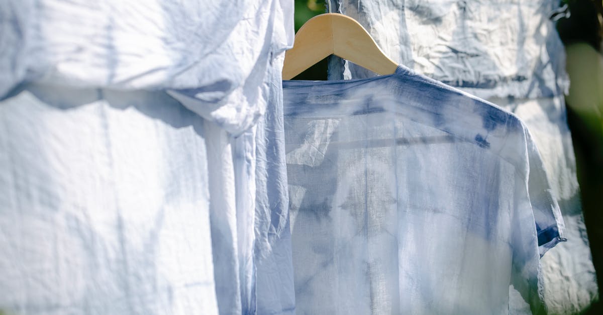 Can I hang cast iron pots and pans to air dry? - Collection of various washed clothes hanging on rope on fresh air on sunny day in summer