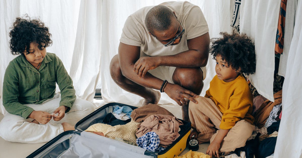 Can I leave boneless chicken breast flat in freezer overnight? - African American father in eyewear with sad kids with curly hair sitting near opened suitcase