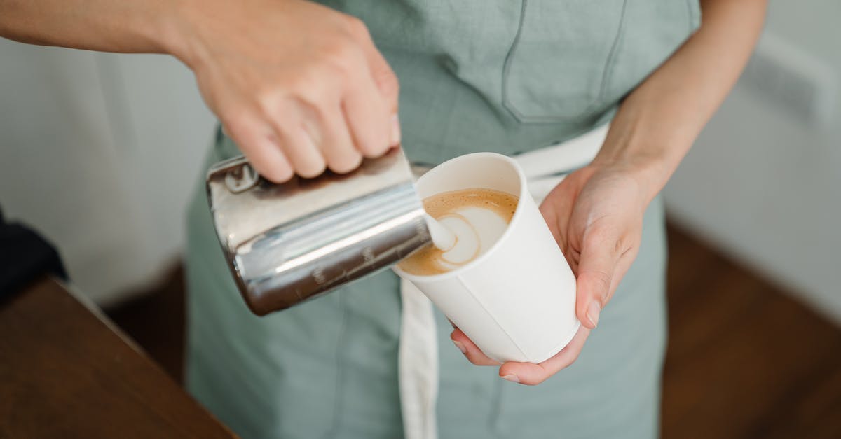 Can I make drinking milk with evaporated milk? - Crop barista pouring milk froth in cappuccino for client