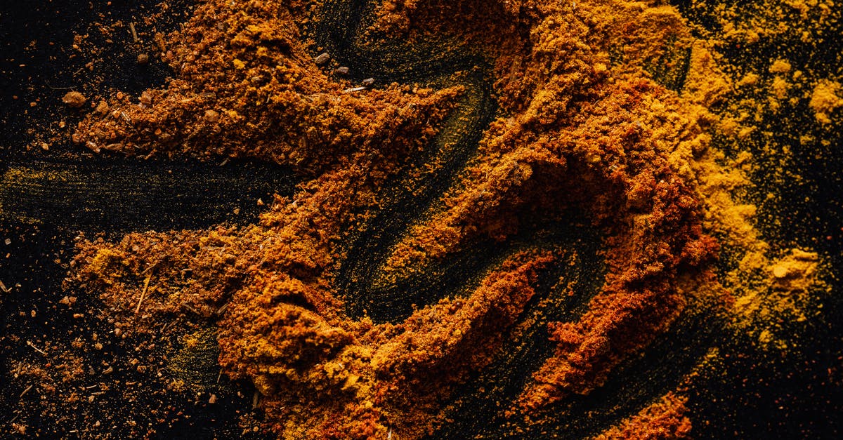 Can I mix a lot of different smoking woods together? - From above of creative design of smoked ground paprika and turmeric mixed together on black surface