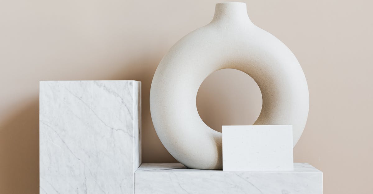 Can I (or should I) re-roughen the interior of a ceramic mortar? - Composition of creative white ceramic vase in ring shape with empty postcard placed on white marble shelf against beige wall as home decoration elements or art objects