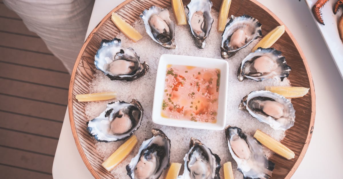 Can I refreeze sauce made from frozen tomatoes - From above of wooden tray with fresh raw oysters served on table with mignonette sauce and lemon slices on chopped ice on yacht