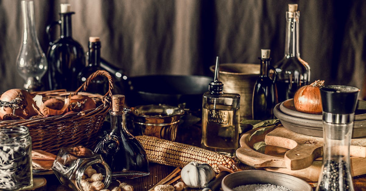 Can I save peanut oil from turkey fryer after rain? - Rustic still life with wooden and wicker utensils among ingredients and bottles of liquids on table