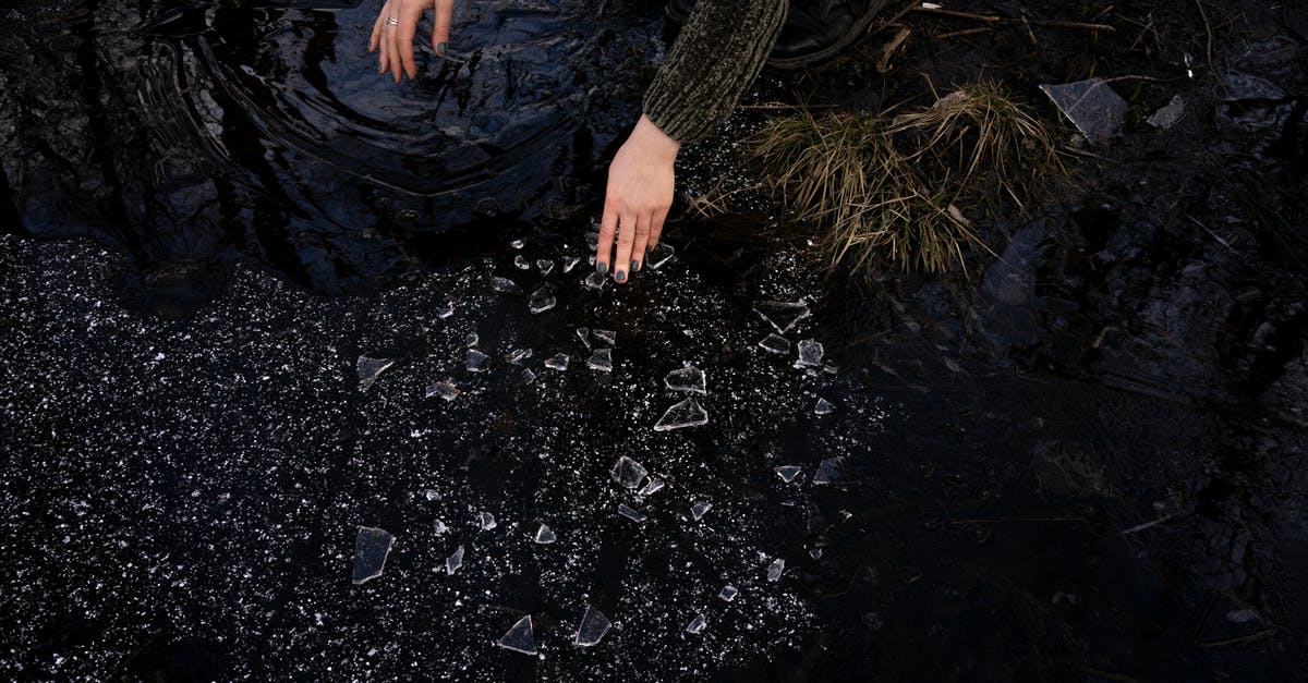 Can I save wet biscuits? - Crop woman picking up broken glass near lake in countryside