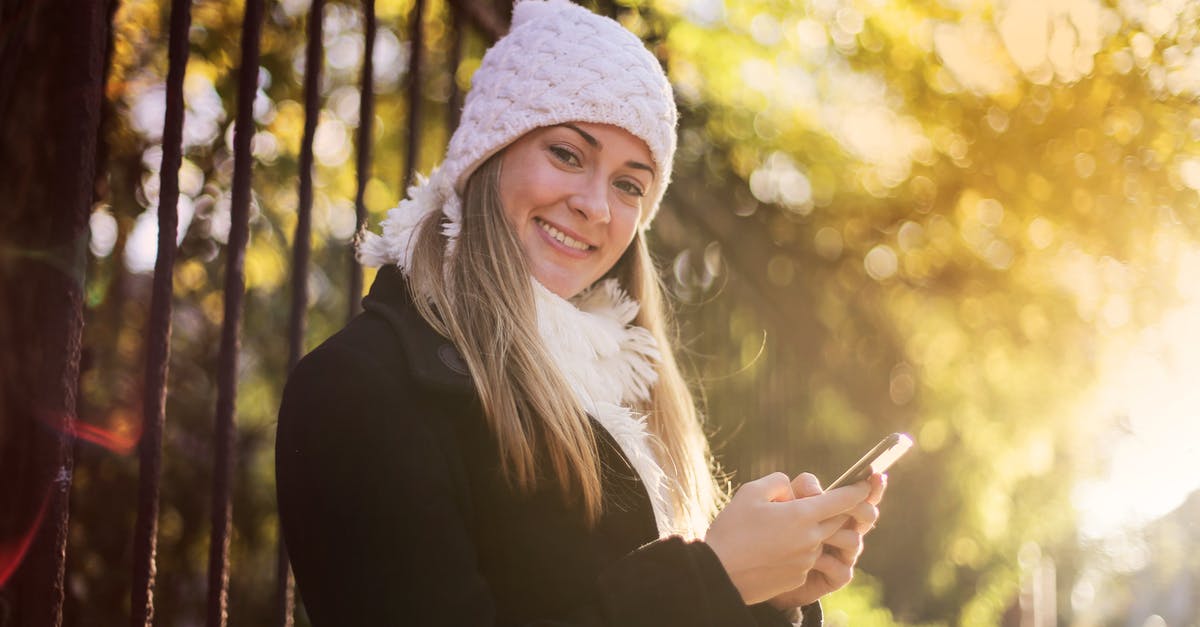 Can I season cast iron *without* using an oven? - Smiling woman chatting on smartphone in park