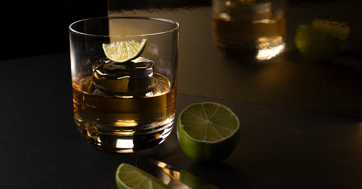 Can I substitute amaretto syrup for amaretto liqueur? - Clear Drinking Glass With Yellow Liquid and Sliced Lime