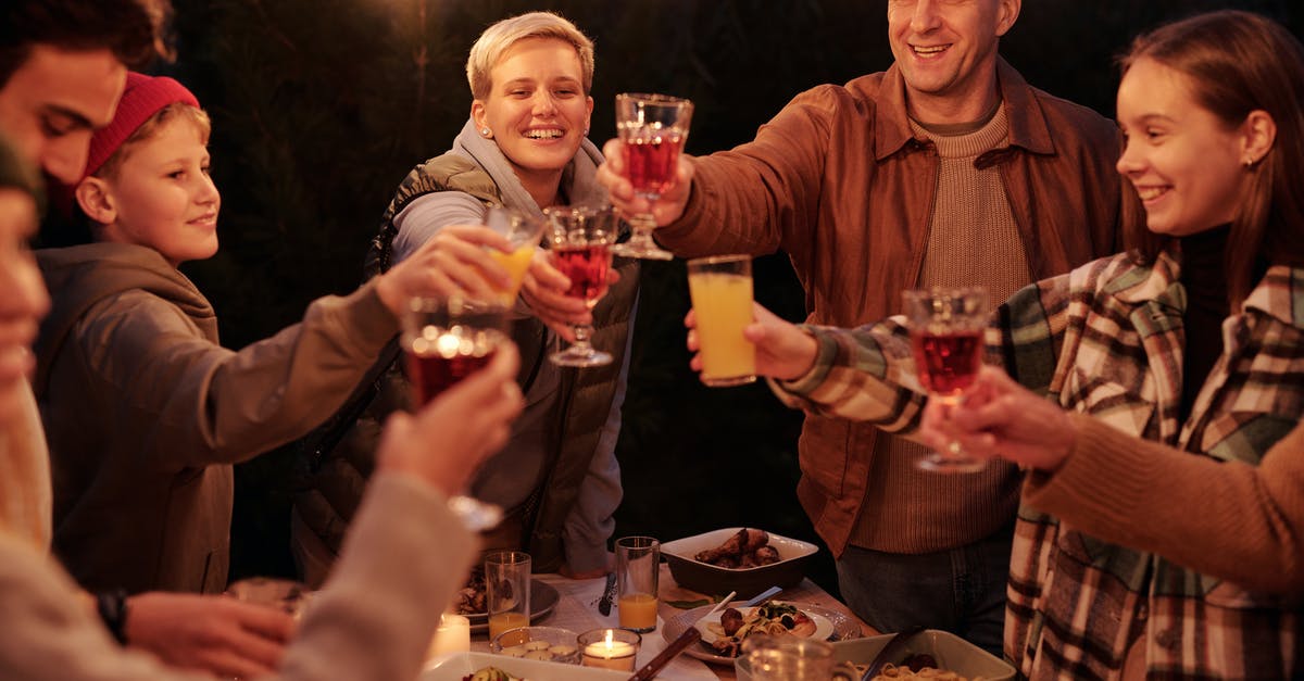 Can I toast pecans the night before? - Laughing friends with kids spending time in backyard at night enjoying dinner with garlands and clinking glasses