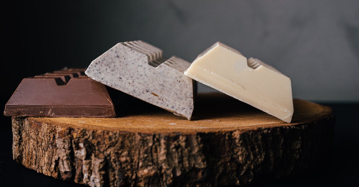 Can I use a dark cocoa candy bar in place of bakers chocolate? - Assorted delicious sweet chocolate bars served on wooden tray against blurred gray background in studio Can I use a dark cocoa candy bar in place of bakers chocolate? - Assorted delicious sweet chocolate bars served on wooden tray against blurred gray background in studio