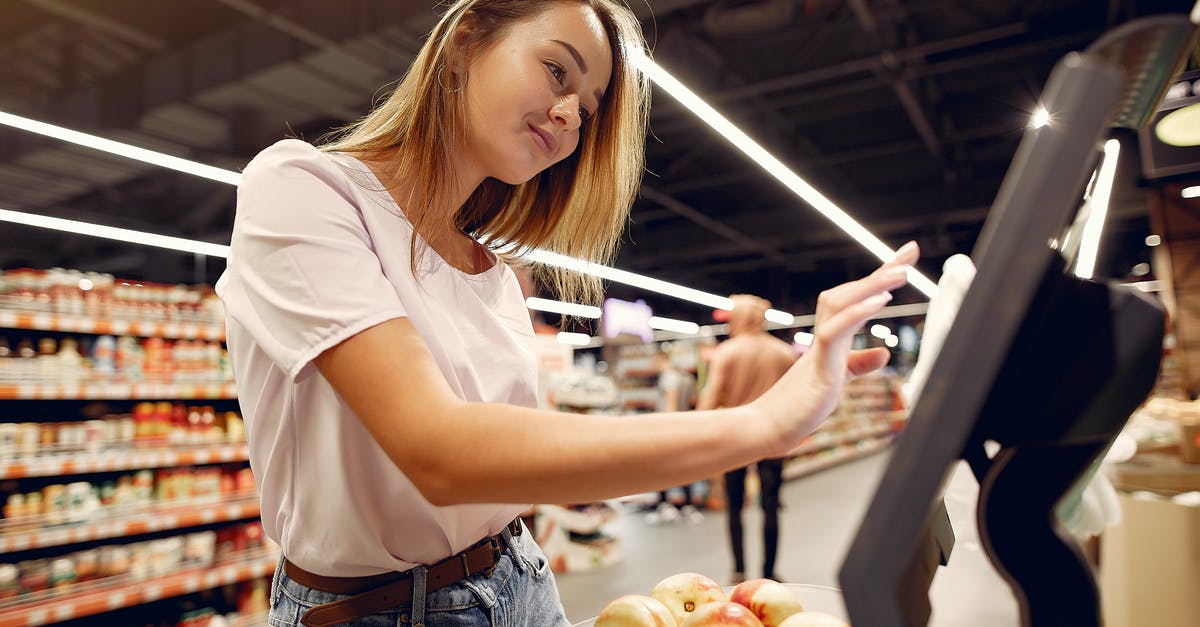 Can I use a fresh peach in place of preserves? - Side view of young woman in trendy clothes weighing peaches on scales while  shopping in supermarket during purchase food