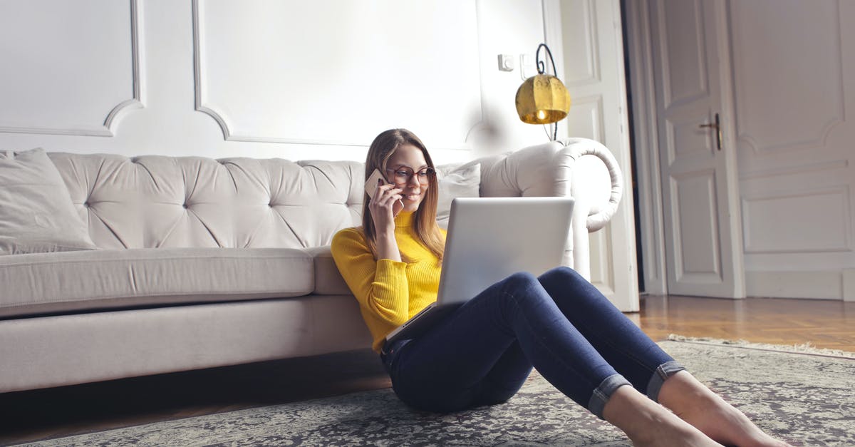 Can I use a larger crockpot than the recipe calls for? - Smiling barefoot female in glasses and casual clothes using laptop and having phone call while sitting on floor leaning on sofa and working on laptop against luxury interior of light living room