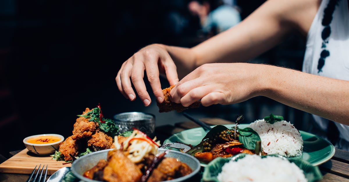 Can I use Basmati Rice for fried rice? - Person Holding Piece of Fried Chicken Above Plate with Food