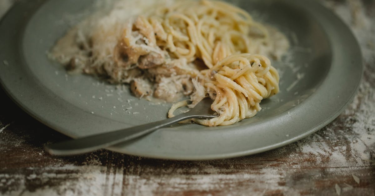 Can I use cream cheese in a sauce? - Fork placed on plate with yummy fresh spaghetti pasta in cream mushroom sauce served on shabby table