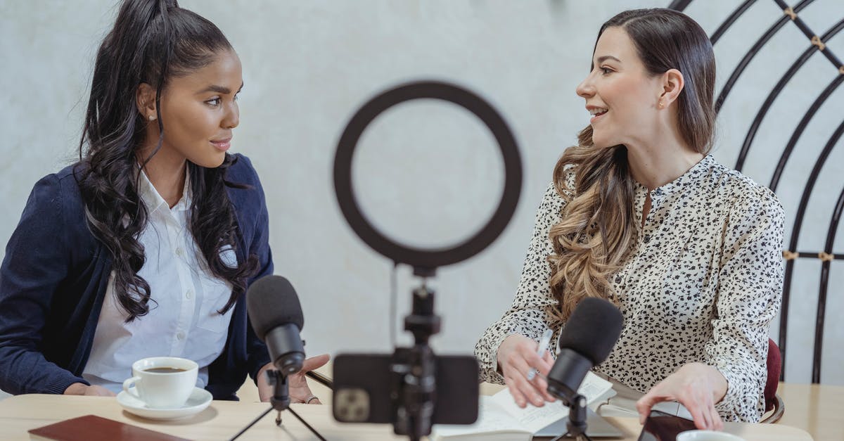 Can I use live yoghurt to kick-start fermentation? - Positive blogger asking questions to African American speaker and recording interview on cellphone at table with microphones